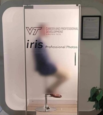 iris photo booth with person inside visible through semi-transparent glass door